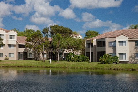 rows of apartment buildings next to a body of water
