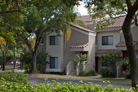 a building with a street and trees in front of it