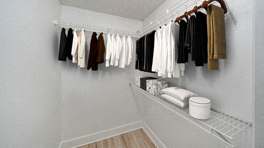 a walk in closet with a rack of clothes