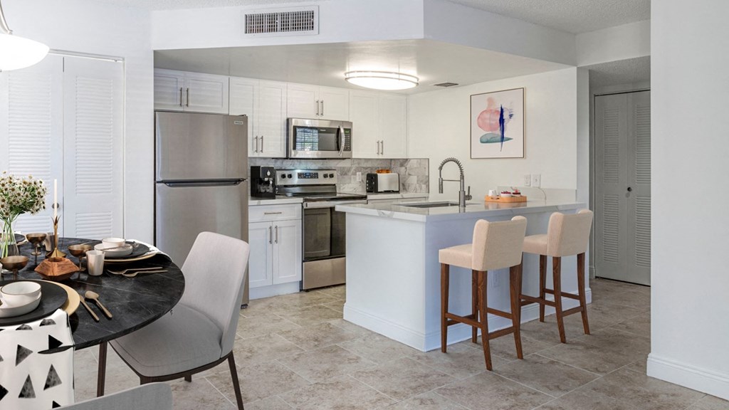 a kitchen with stainless steel appliances and a table with chairs