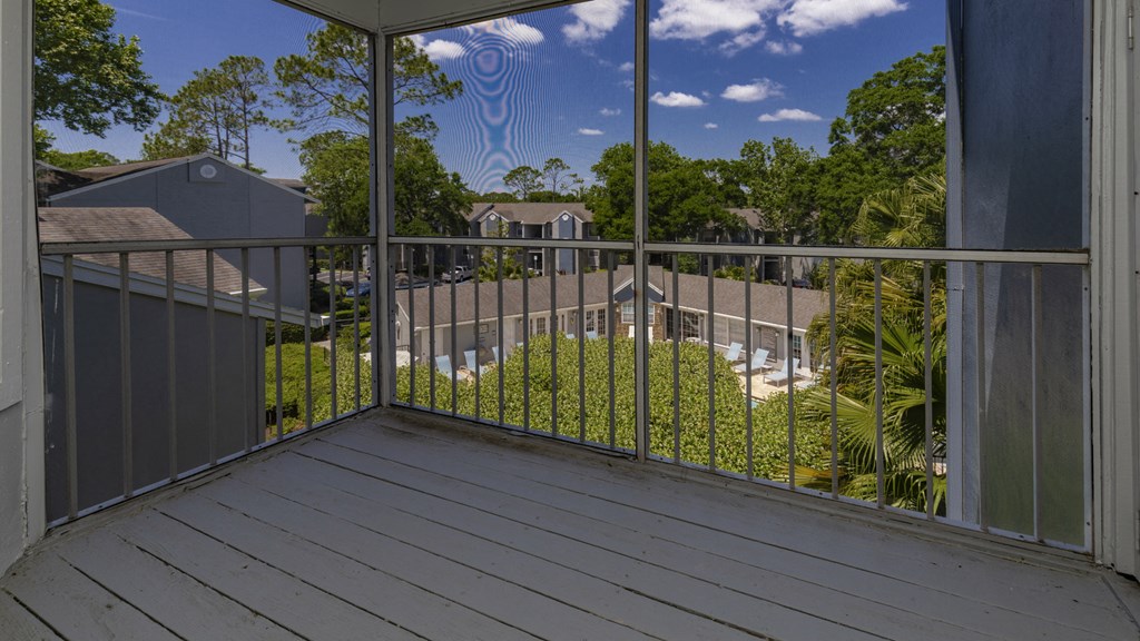 a balcony with a view of a yard and some trees