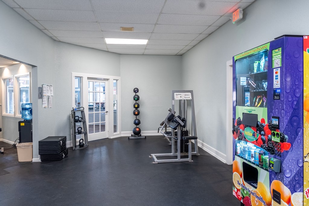 a fitness room with a vending machine and other exercise equipment