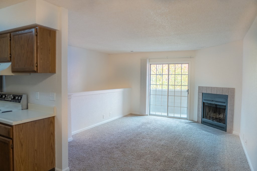 an empty living room with a fireplace and a window