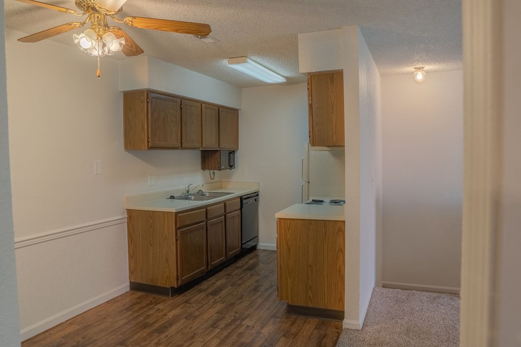 A kitchen with wooden cabinets and a ceiling fan.