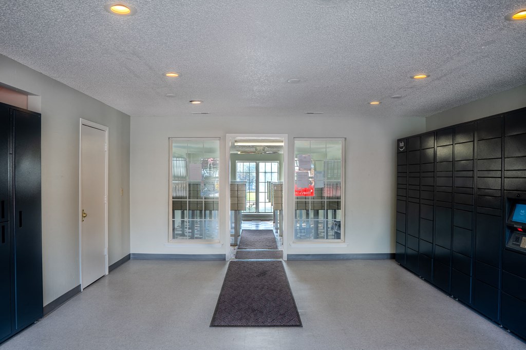 a hallway with glass doors and a rug in the center of the room