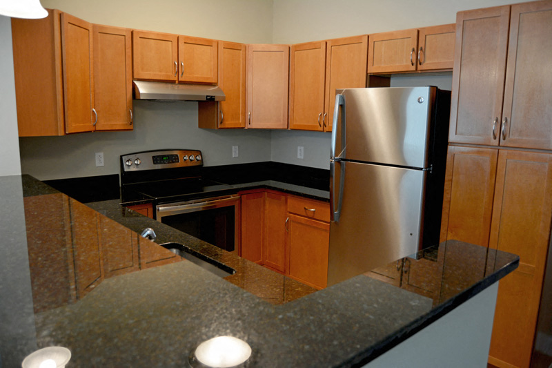 a kitchen with granite counter tops and a stainless steel refrigerator