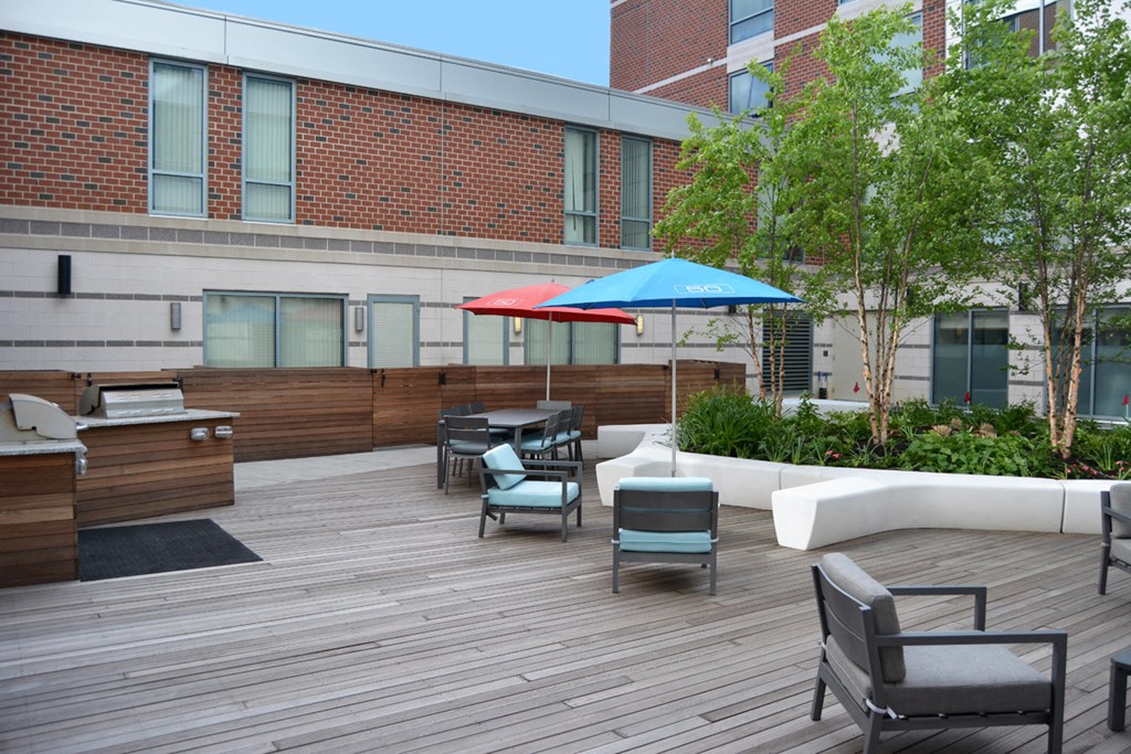 a rooftop patio with tables and chairs and umbrellas