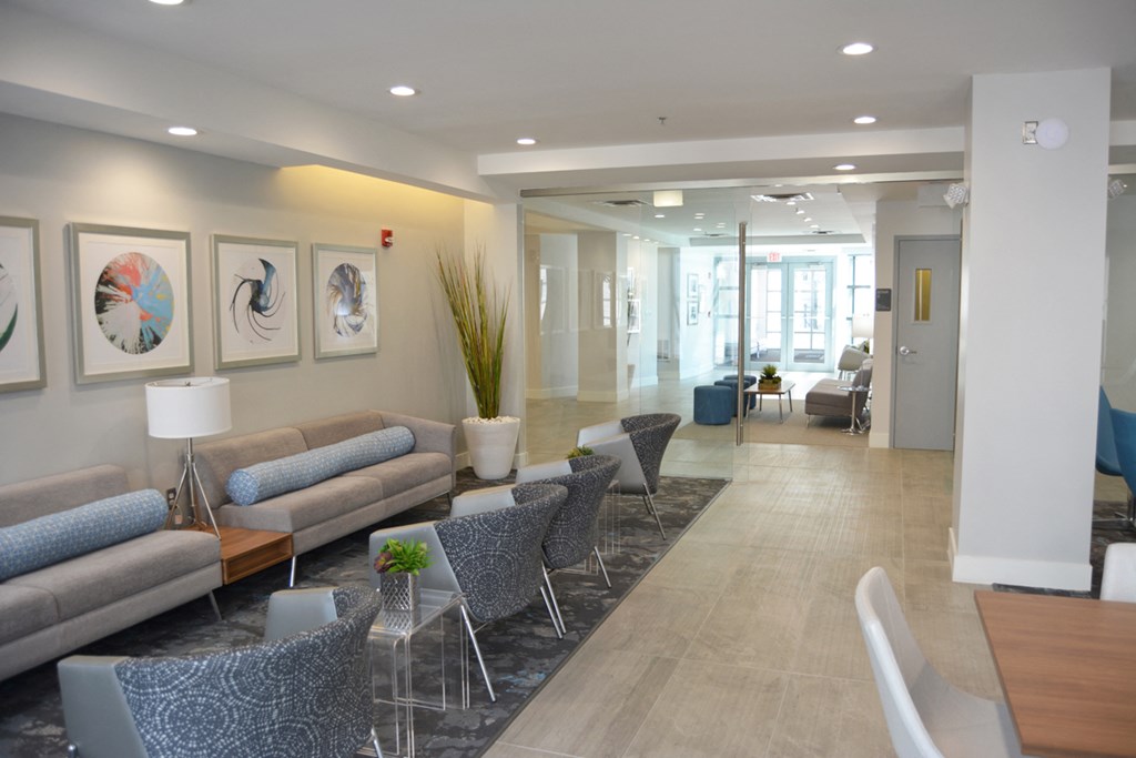 a lobby with couches and chairs and a table with chairs