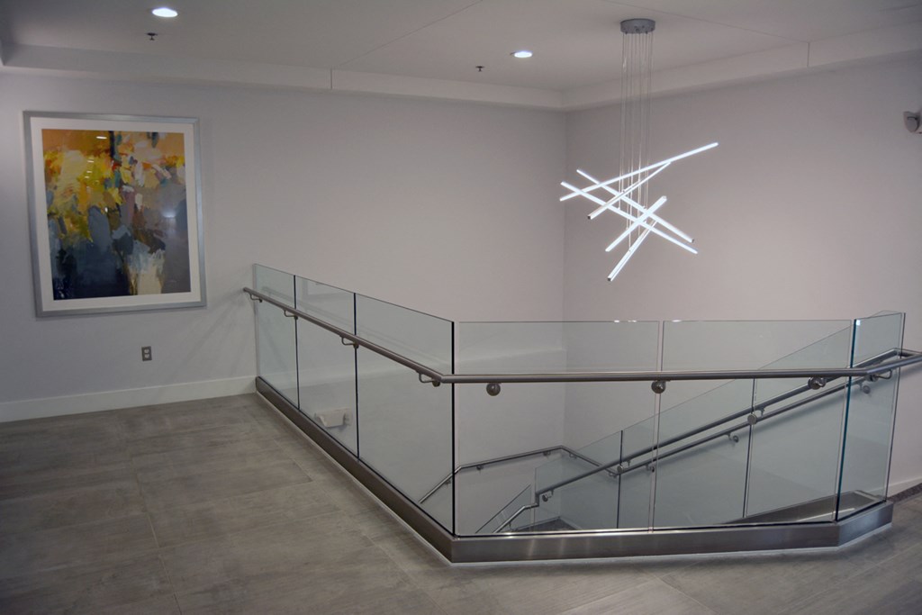 a large museum room with glass railing and a chandelier