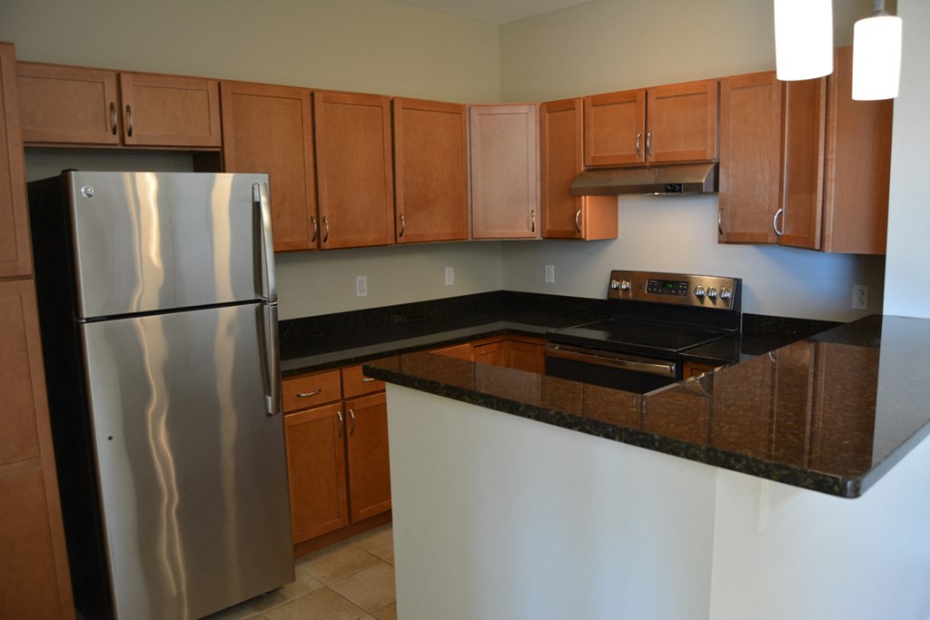 a kitchen with an island and stainless steel refrigerator