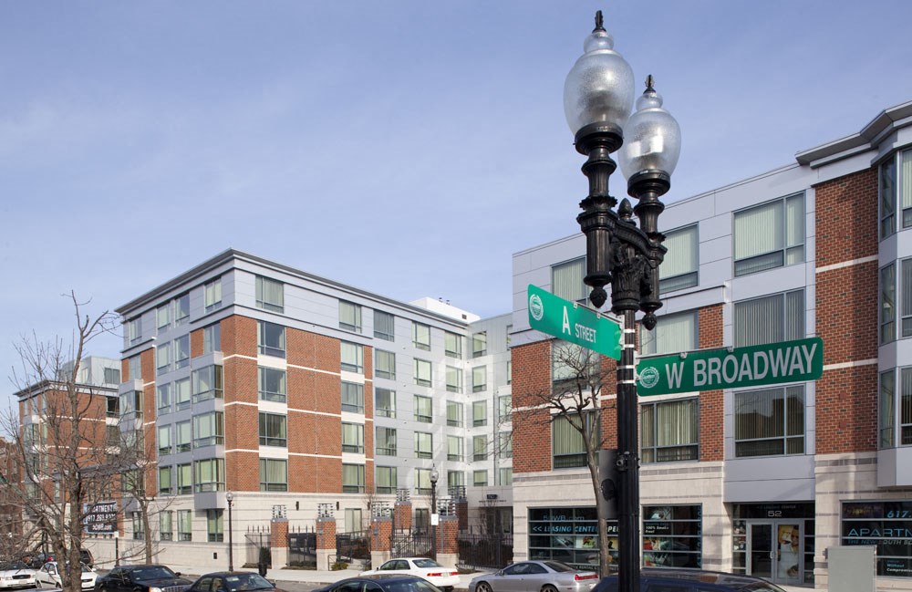a street light with street signs in front of a building