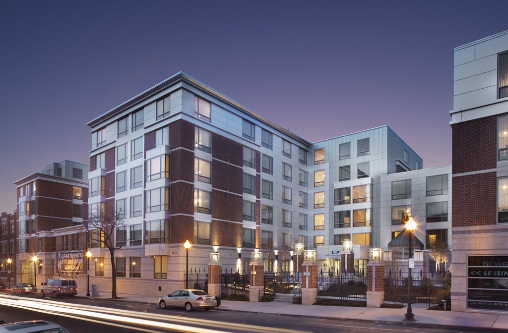 a rendering of an apartment building on a city street at night