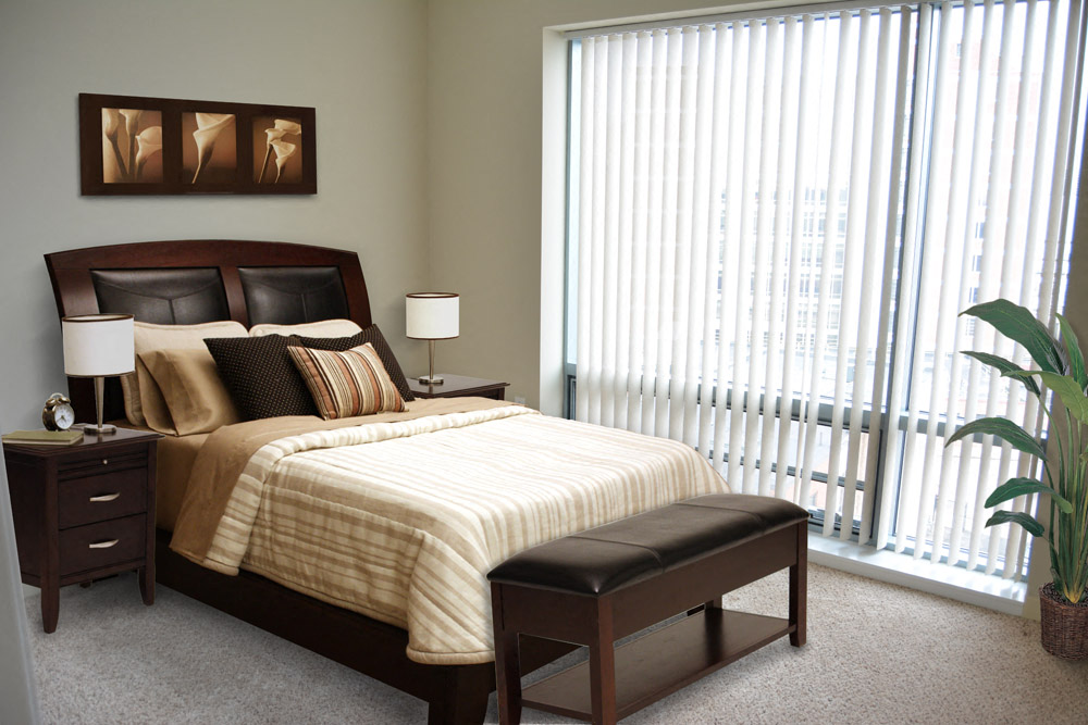 a bedroom with a bed and a large window