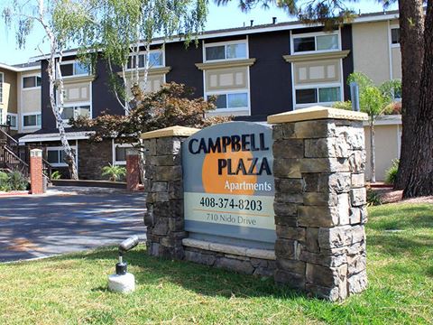 a sign for campbell plaza apartments in front of a building