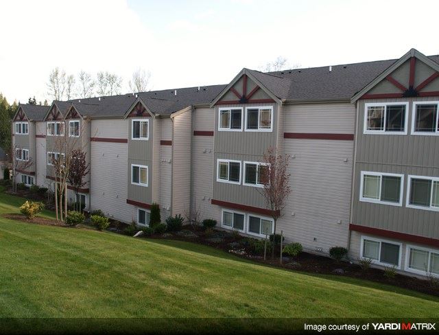 a row of apartment buildings with grass in front of them