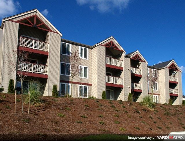 an apartment building on a hill with a blue sky