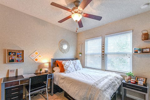 a bedroom with a large bed and a ceiling fan