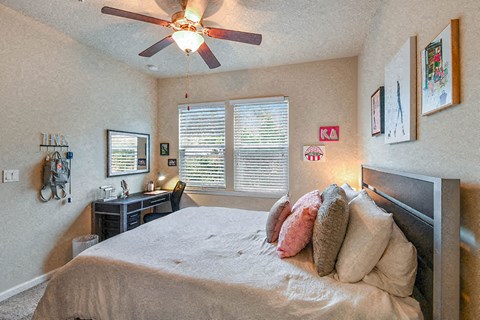 a bedroom with a large bed and a ceiling fan