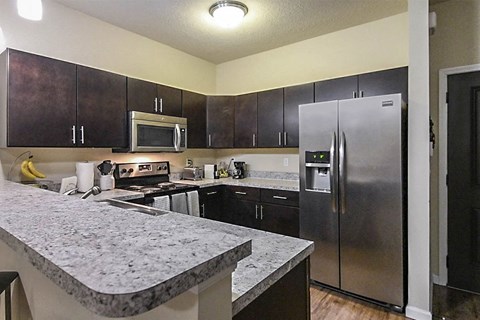 a large kitchen with stainless steel appliances and granite counter tops