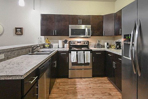 a kitchen with stainless steel appliances and marble counter tops