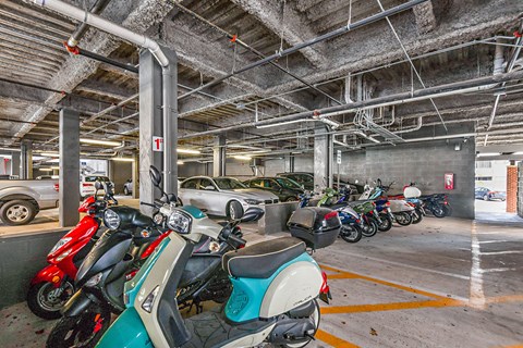 a parking garage filled with motorcycles and cars