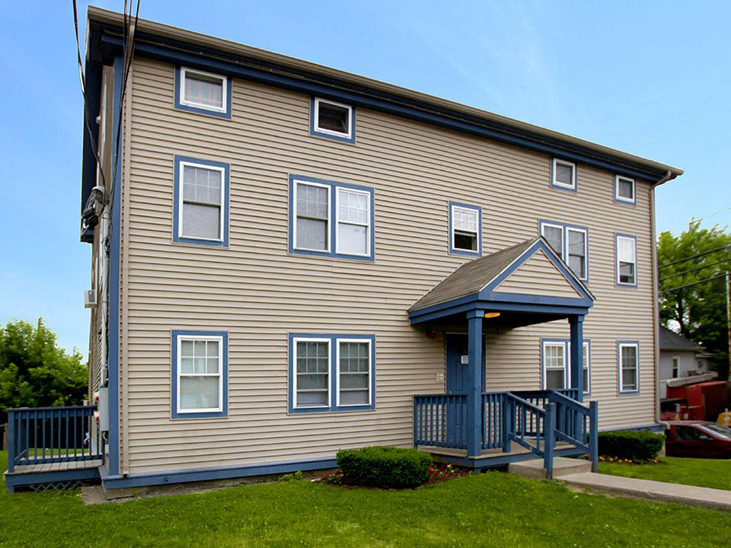 a yellow house with a porch and a blue staircase