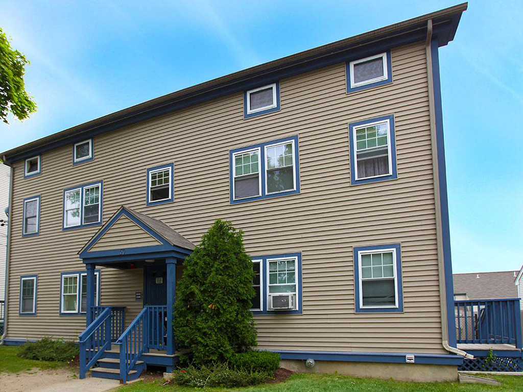 a brown house with a blue porch and stairs