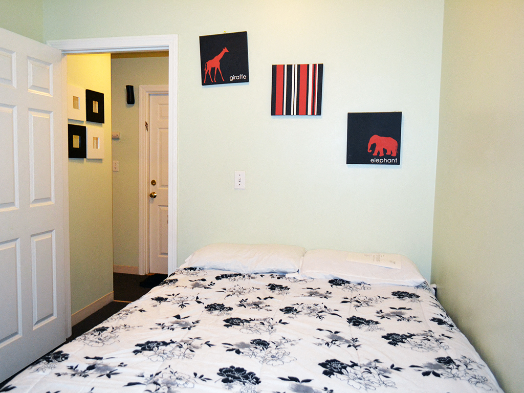 a bedroom with a bed and pictures on the wall