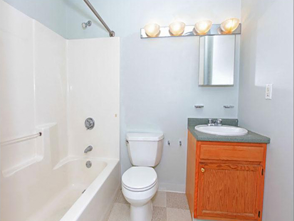 a bathroom with a toilet and a sink and a bath tub
