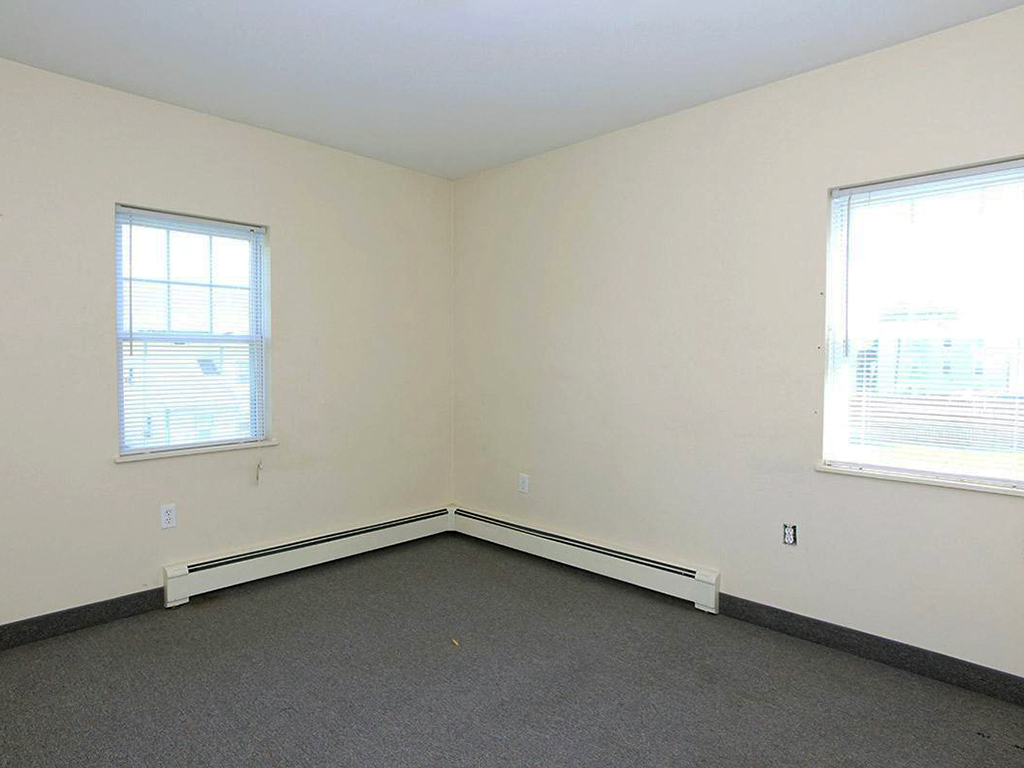 an empty room with two windows in it