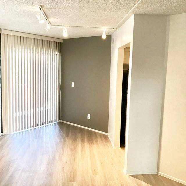 an empty living room with a wood floor