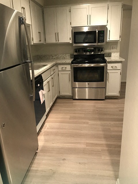 a kitchen with stainless steel appliances and white cabinets