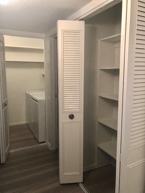 a white closet with white shelves and a door