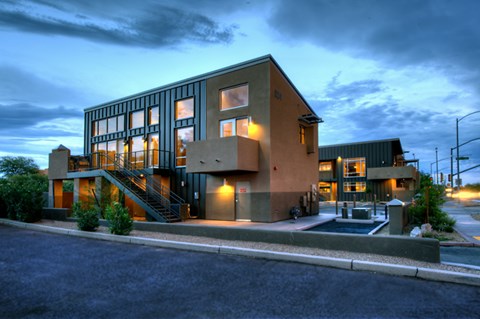a house with glass windows at night with the sky