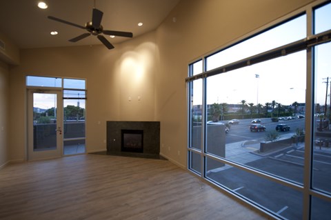 an empty living room with a fireplace and a large window