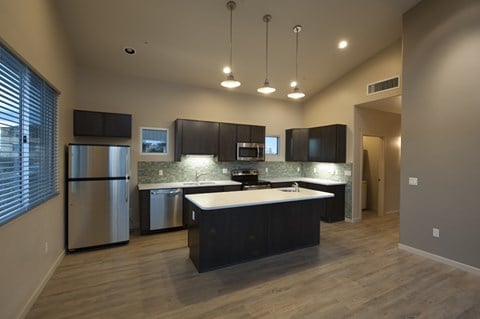 a kitchen with a large island and a stainless steel refrigerator