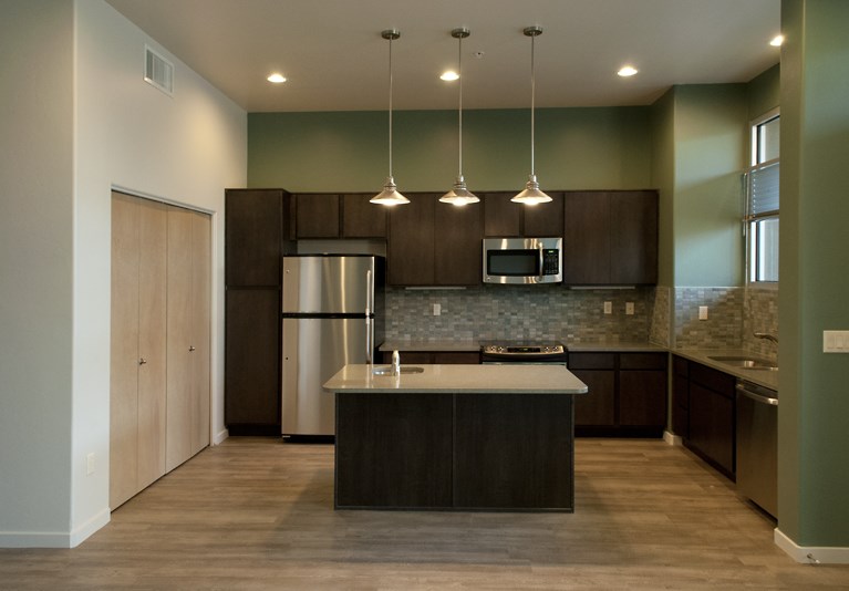 a kitchen with a large island and a refrigerator