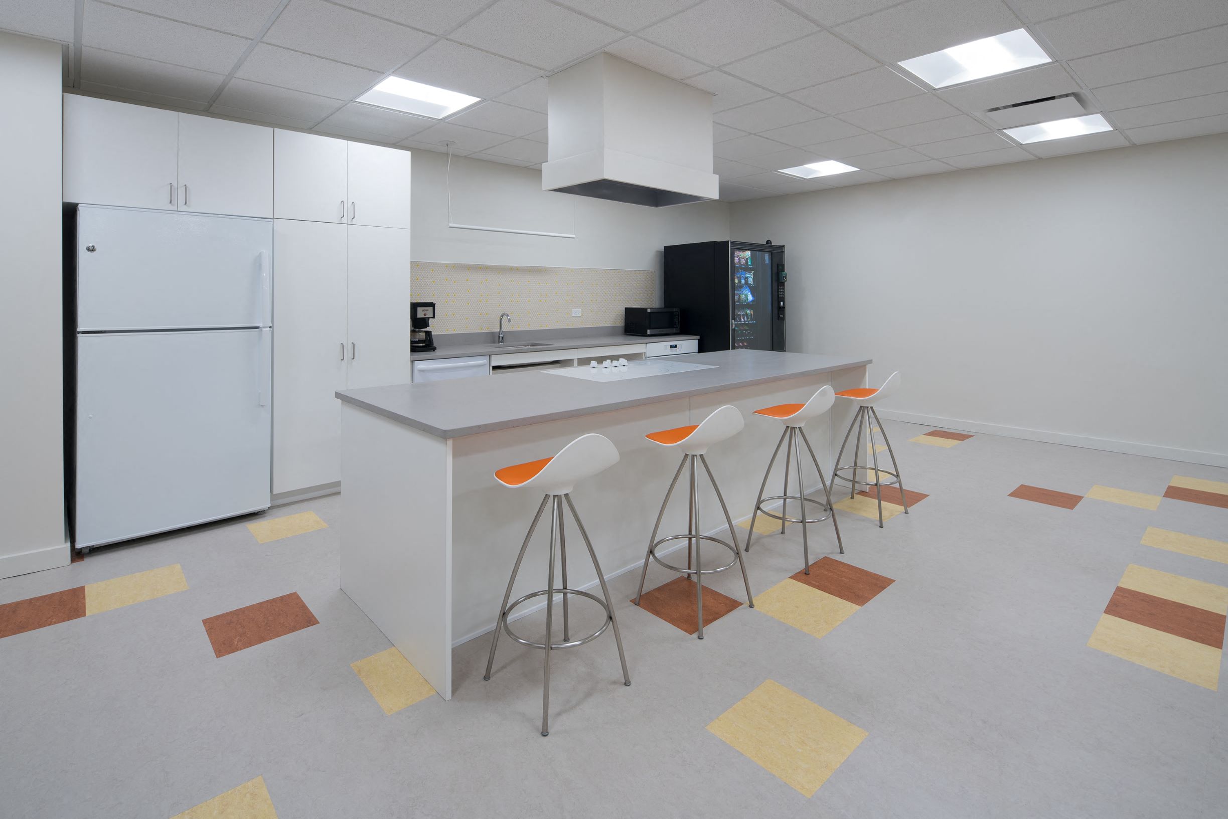a kitchen with a counter and chairs in front of a counter top