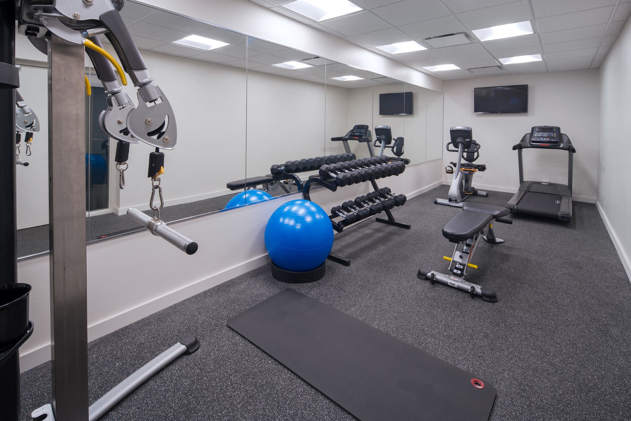 a gym with exercise equipment and weights in a building