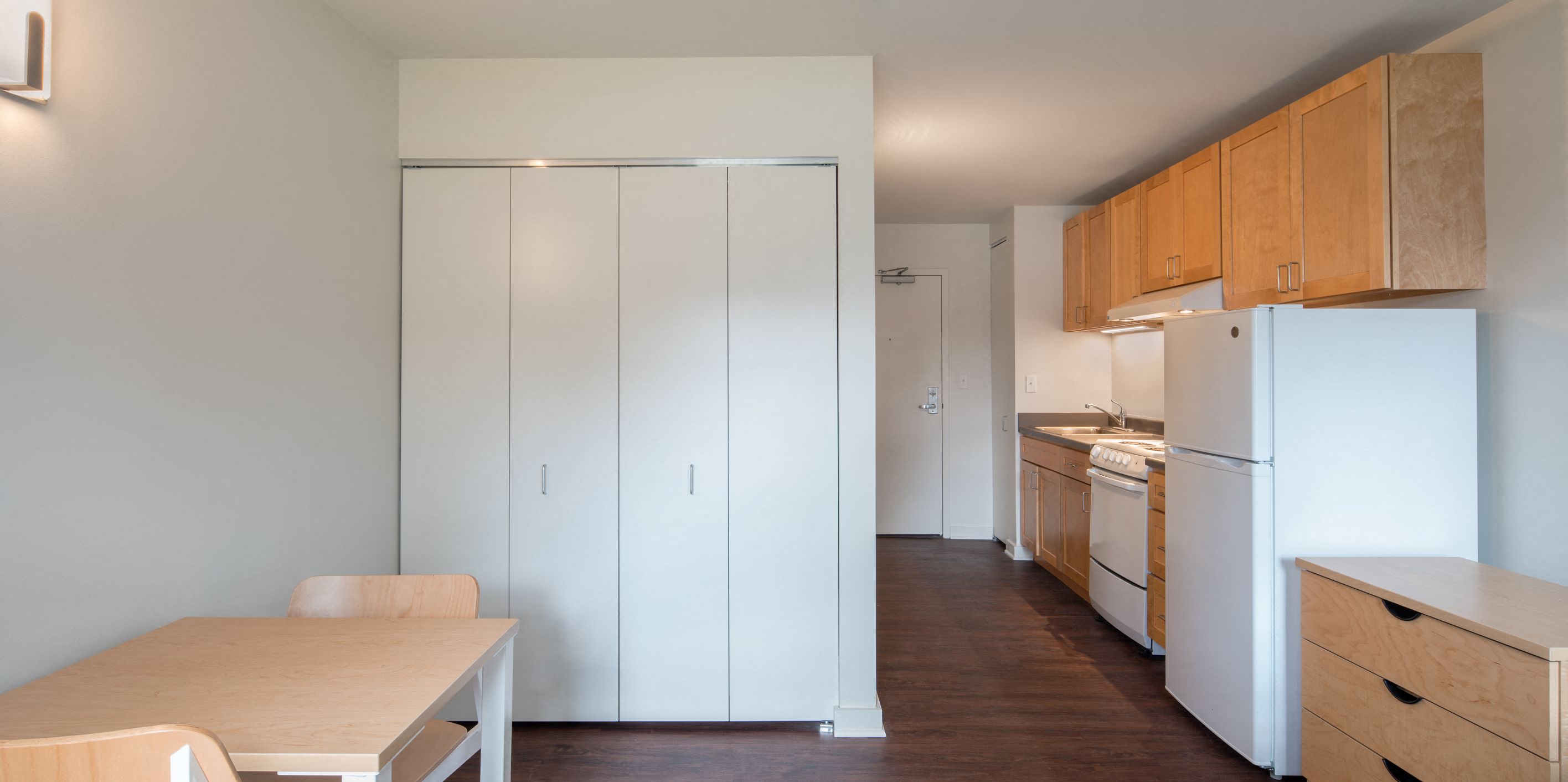 a kitchen with white appliances and wooden cabinets and a table