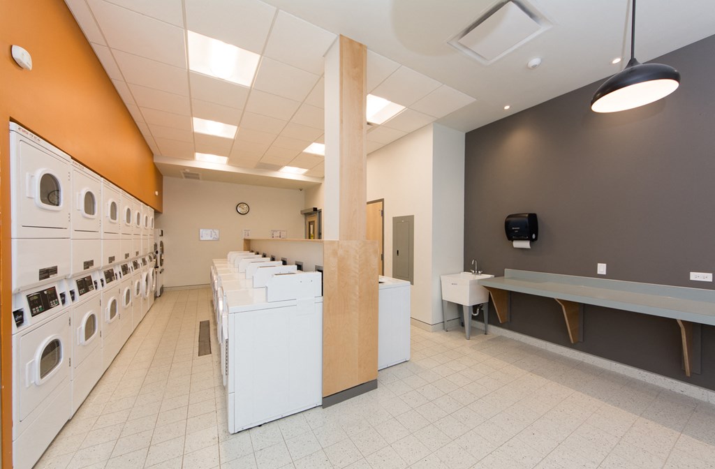 a laundry room with washers and dryers and a counter with sinks