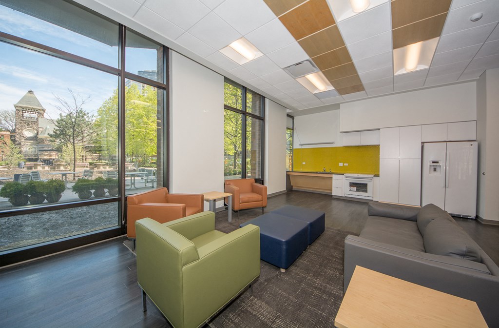 a lounge area with couches and chairs in a room with large windows