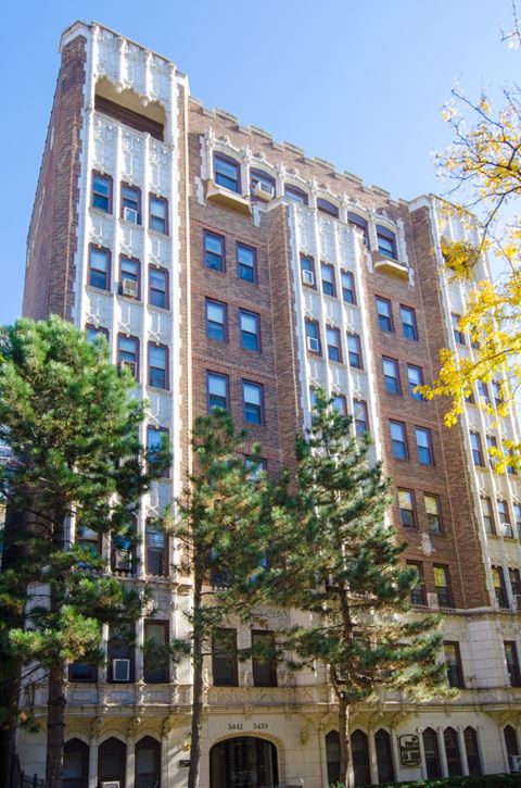 a tall brick building with trees in front of it
