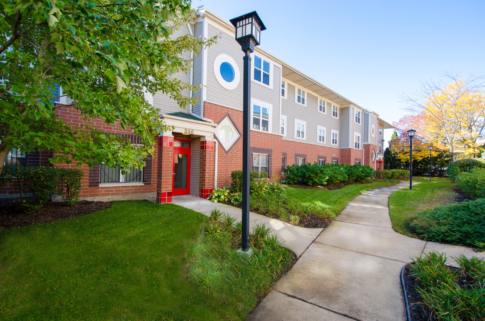 a sidewalk in front of a brick building with a street light
