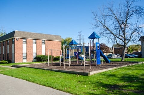 a playground in front of a brick building
