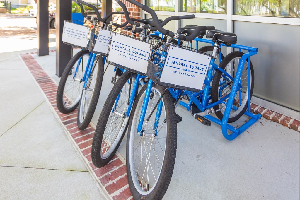 a row of blue bikes parked outside of a building