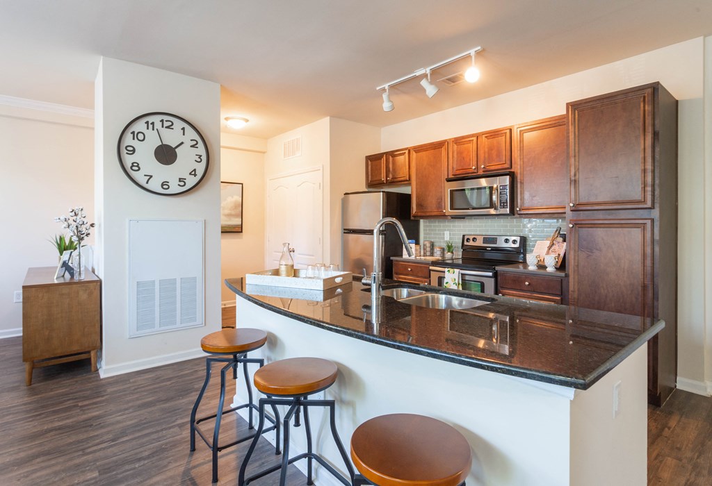 a kitchen with a counter top and a large clock on the wall