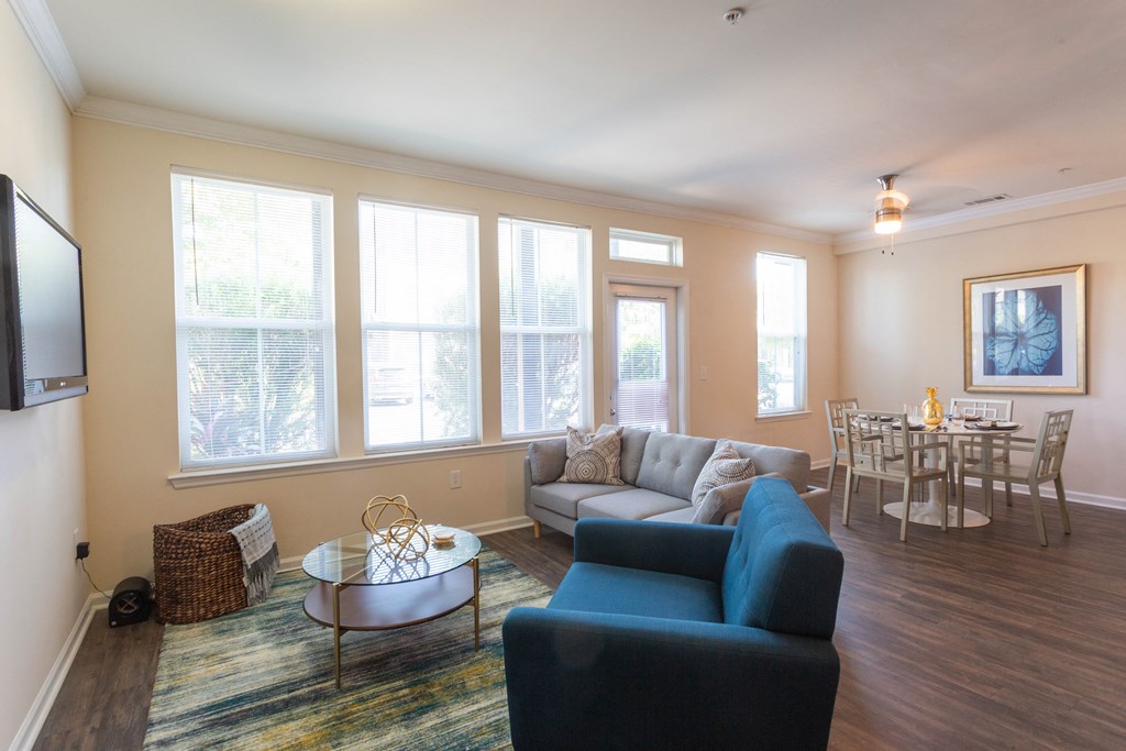 a living room with a couch and a chair and a table with a dining room