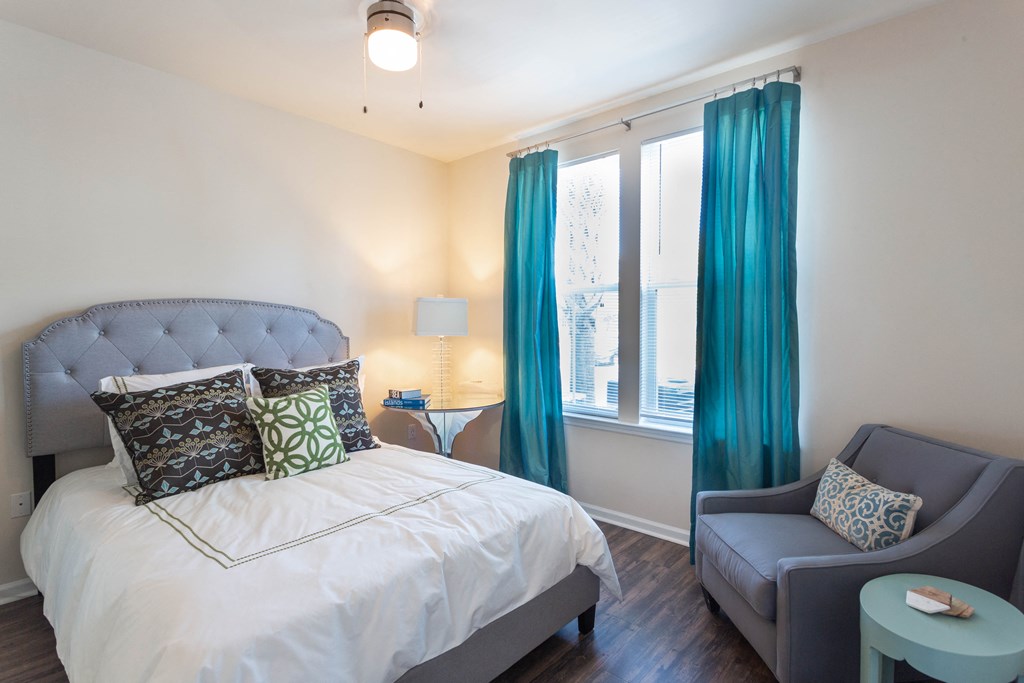 a bedroom with a white bed and blue curtains