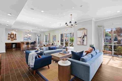 A living room with a blue couch and a wooden floor.
